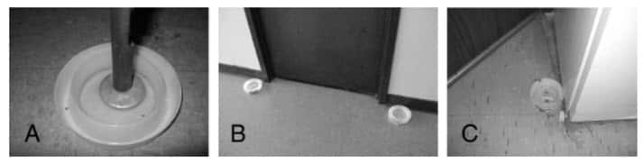 Figura. 1. Interceptores colocados en apartamentos para la detección de chinches y su dispersión entre los apartamentos: (A) un interceptor bajo una pata de la cama, (B) dos interceptores en el pasillo al lado de una puerta del apartamento, y (C) un interceptor detrás de la puerta de entrada.